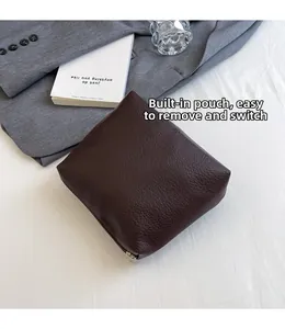 Detail of dark brown lychee texture leather pouch with a silver zipper for tote bag