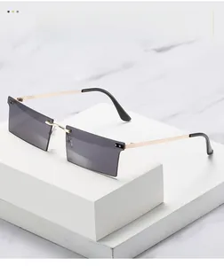 Détail de lunettes de soleil carrées sans monture avec verres dégradés et branches dorées