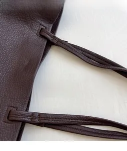 Detailed close-up of stitching on dark coffee lychee leather tote bag shoulder straps