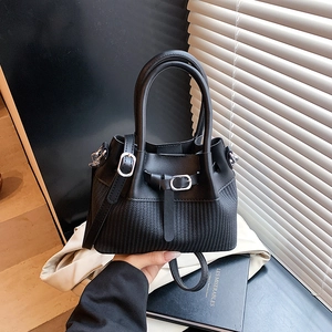 Sac à main chic noir avec texture matelassée et détails argentés en décor moderne