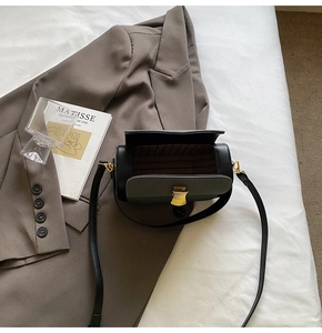 Detailansicht des braun gestreiften Futters und des Goldverschlusses der schwarzen Zylindertasche