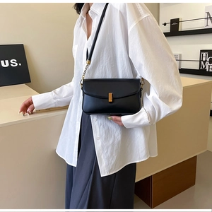 Détail du sac à bandoulière en cuir noir avec longue boucle en métal doré élégant