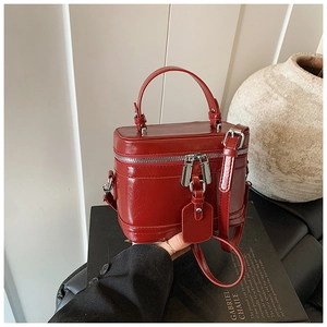 Detail der roten glänzenden Leder-Box-Tasche mit Doppelreißverschluss und Rundgriff