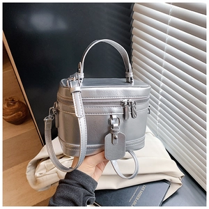 Details der silbernen Box-Tasche mit metallischer Ledertextur und gewölbtem Griff