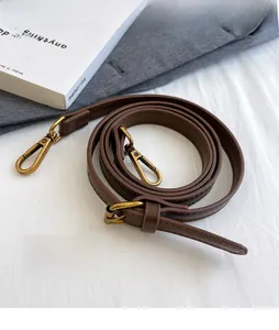 Détail d'une bandoulière réglable en cuir PU marron avec boucles en bronze antique