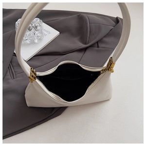 Detail view of white crescent shoulder bag showing interior capacity and golden zipper