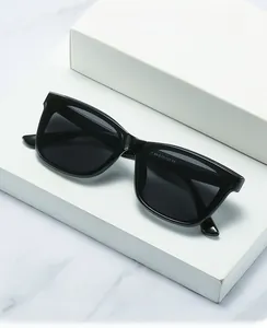 Detail of square black sunglasses with wide temples and specifications on white marble