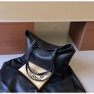 Detailed view of the black lychee pattern leather texture on a large capacity tote bag