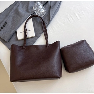 Close-up of brown litchi pattern tote bag and matching inner pouch on minimalist background