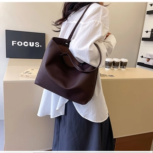 Close-up of large coffee brown tote bag with premium lychee grain leather texture