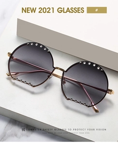 Détail de lunettes de soleil rondes de luxe avec strass argentés sur monture dorée