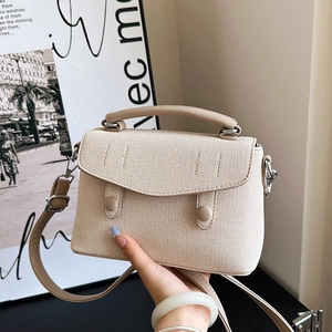 Chic beige textured woven mini handbag with leather handles and adjustable shoulder strap