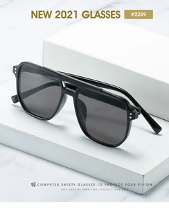 Detail of retro black double bridge sunglasses with gold rivet accents on marble background
