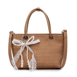 Handmade straw handbag with white lace bow and pearl charms on a white background