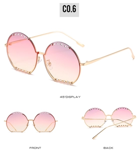 Vues détaillées des lunettes soleil rondes à strass avec verres dégradés rose-orange et doré