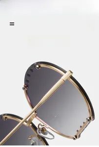 Détail de lunettes de soleil demi-cerclées dorées avec monture métallique ultra-souple