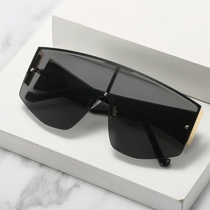 Oversized one-piece flat top sunglasses with dark lenses and gold metal temple accents