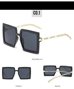 Detail view of large square sunglasses with stylish golden metal chain temples on black frames