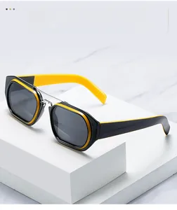 Detailed view of square double-bridge sunglasses with black and yellow frame on a marble base