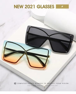 Close-up of oversized shield sunglasses with butterfly metal frames and silver rivets