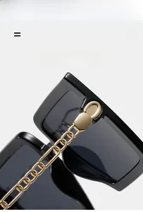 Macro shot of stylish gold chain hinges on large square black sunglasses frames