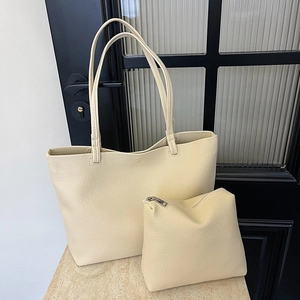 Minimalist beige large tote bag set with pebble leather texture on stone display