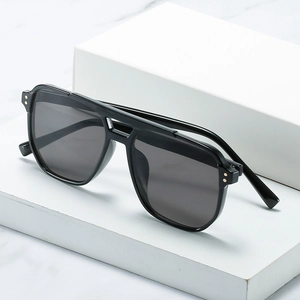 Retro double bridge square black sunglasses with metal rivets on marble background