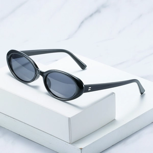 Retro kleine ovale Sonnenbrille mit schwarzem Rahmen und grauen Gläsern auf Marmor