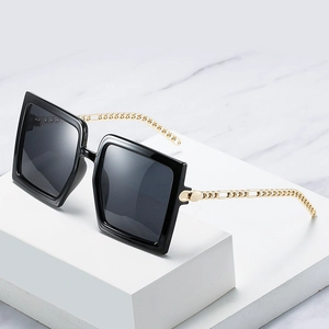Fashionable oversized square sunglasses with black frames and gold chain-link metal temples