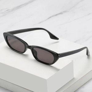 Lunettes de soleil œil-de-chat noires classiques à monture étroite sur présentoir géométrique