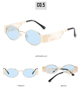 Detail view of oval sunglasses with gold frames, blue lenses and cutout carved temples