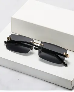 Detail of rimless rectangular sunglasses with gold metal hinges and gradient black lenses