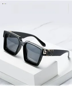 Detail view of black square sunglasses with luxury gold metal decor on marble stairs