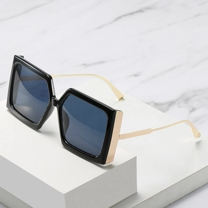 Lunettes de soleil oversize tendance avec monture noire et branches en métal doré