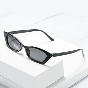 Chic black cat eye sunglasses with dark lenses on a white marble background for women