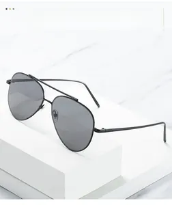 Detail view of classic aviator sunglasses with black metal double bridge and dark lenses