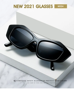 Close-up of black oversized cat eye sunglasses on a minimalist white geometric display