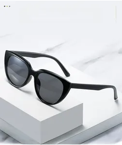 Detail of trendy black cat-eye sunglasses with glossy PC frame on marble background