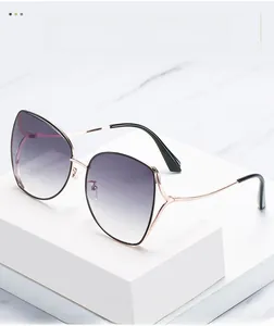 Detail of rose gold cat-eye sunglasses with gradient purple lenses on a white pedestal