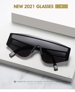 Flat lay of square oversized black sunglasses on white marble, minimalist modern eyewear