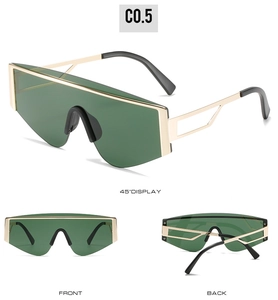 Detail view of square oversized sunglasses with gold metal frame and dark green lenses