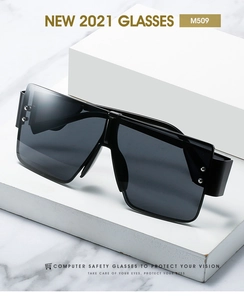 Close-up of oversized square black glasses M509 with silver rivet details on white marble
