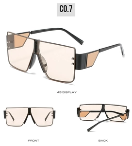 Detail view of oversized one-piece sunglasses with light brown lenses and hollow temples