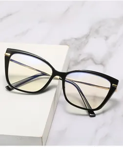 Détail de lunettes anti-lumière bleue œil-de-chat noires avec branches dorées sur marbre