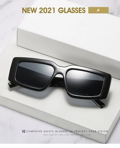 Vue détaillée de lunettes de soleil rectangulaires noires sur une surface en marbre