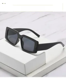 Détail de lunettes de soleil carrées à monture noire épaisse sur des marches en marbre