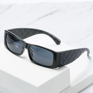 Modische schwarze quadratische Sonnenbrille mit strukturierten breiten Bügeln auf Stativ