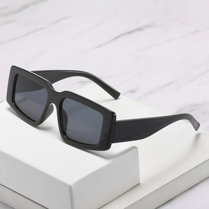 Lunettes de soleil carrées noires avec verres foncés sur un fond en marbre chic