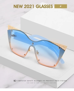 Detail of gradient lenses and gold hollow metal lace trim on cat eye sunglasses