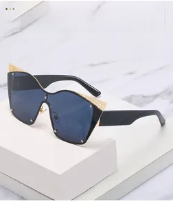Close-up of golden filigree decoration and metal rivets on oversized cat eye sunglasses